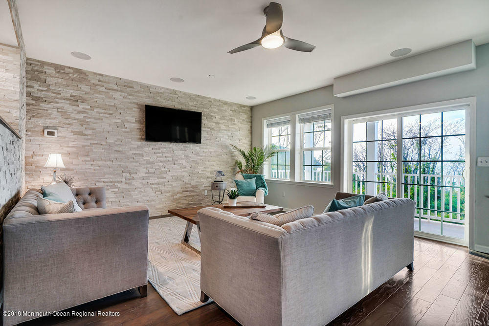 11 Lighthouse Point Road, Unit 601 Highlands, NJ 07732 - Photo 29 of 79 a living room with furniture floor to ceiling window hardwood floor and a flat screen tv