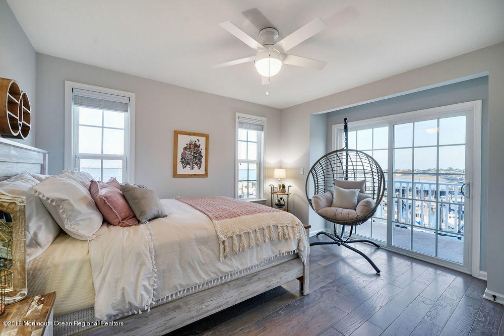 11 Lighthouse Point Road, Unit 601 Highlands, NJ 07732 - Photo 35 of 79 a bedroom with a bed a window and a chandelier