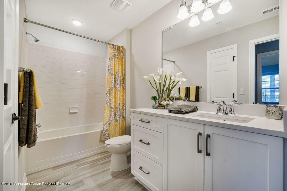 11 Lighthouse Point Road, Unit 601 Highlands, NJ 07732 - Photo 9 of 79 a bathroom with a double vanity sink a toilet a mirror and shower