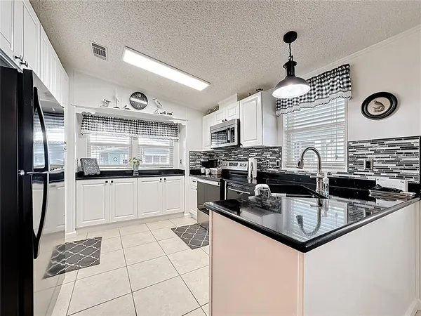 a kitchen with granite countertop a sink stainless steel appliances and cabinets