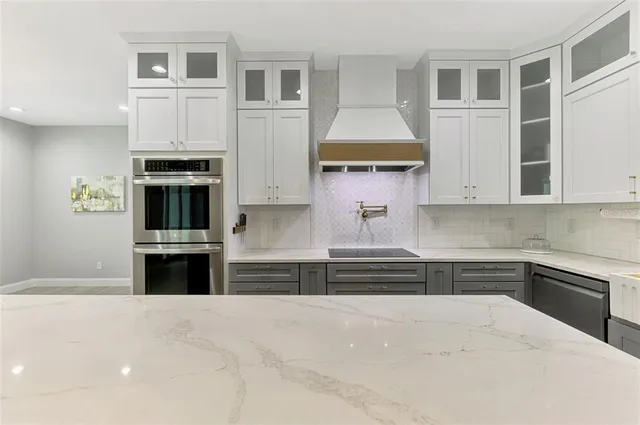 a kitchen with stainless steel appliances kitchen island granite countertop a stove and cabinets