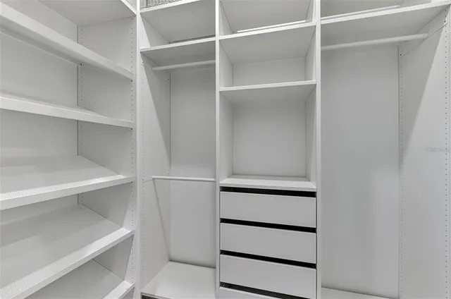 a view of walk in closet with empty racks