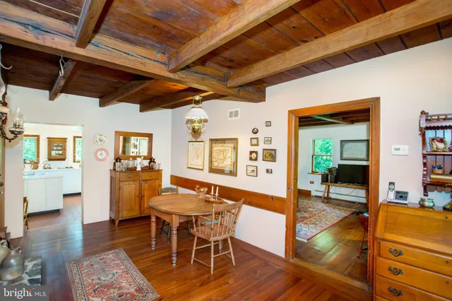 a room with a table chairs and a large window