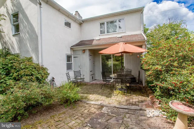 a view of a house with a small yard plants and large tree