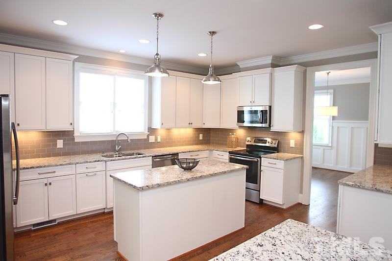 508 Mial Street Raleigh, NC 27608 - Photo 11 of 25 The kitchen is a chef's delight with tons of cabinets, including glass door cabinets to display your finest and funnest. Granite, tile backsplash, under cabinet lighting, stainless appliances...an island as well as an eating peninsula.