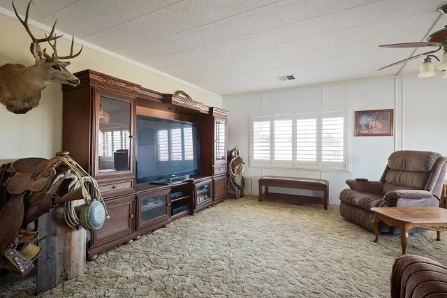 a view of wooden house with large trees and wooden fence