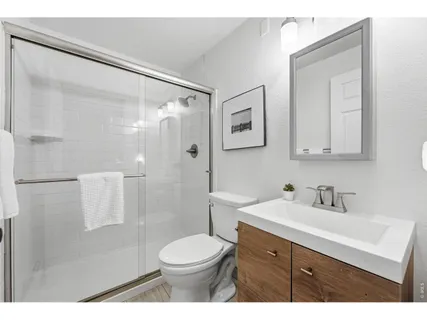 a bathroom with a sink a toilet and shower