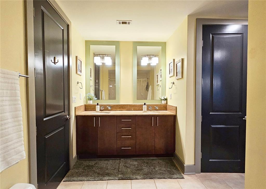 4561 Olde Perimeter Way, Unit 2407 Atlanta, GA 30346 - Photo 12 of 40 a spacious bathroom with a granite countertop sink and a mirror
