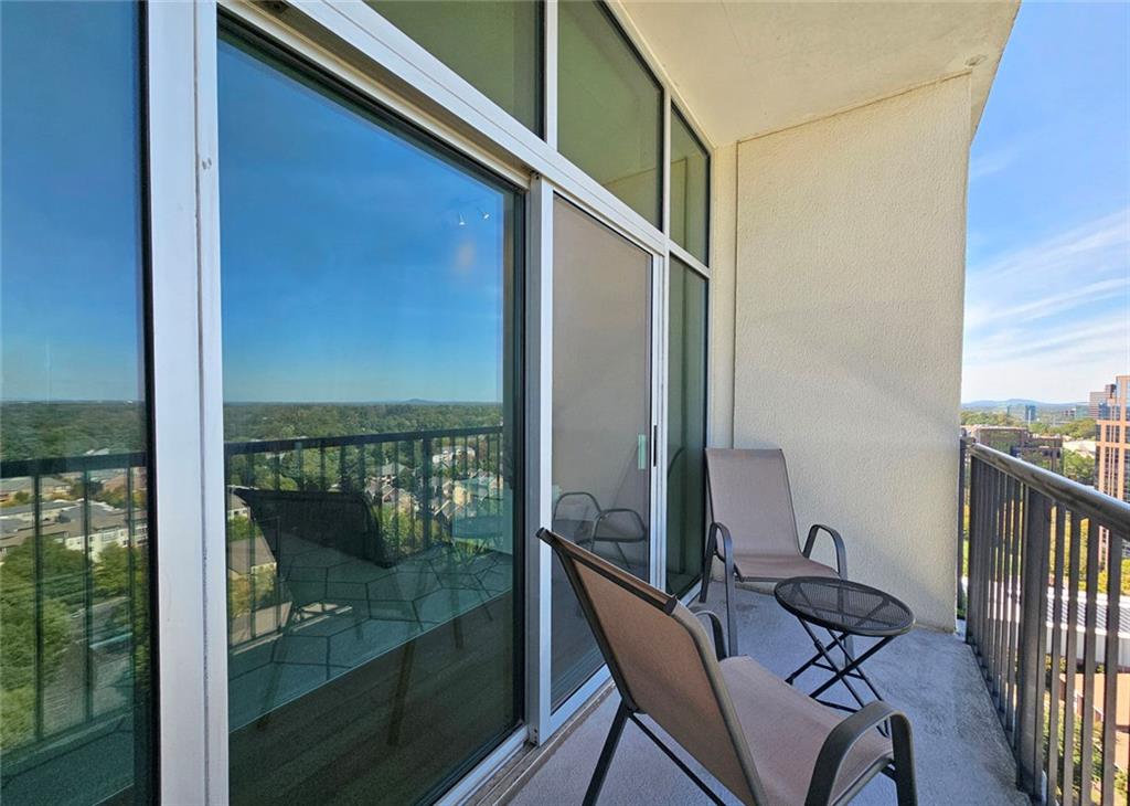 4561 Olde Perimeter Way, Unit 2407 Atlanta, GA 30346 - Photo 16 of 40 a balcony with chairs and wooden floor