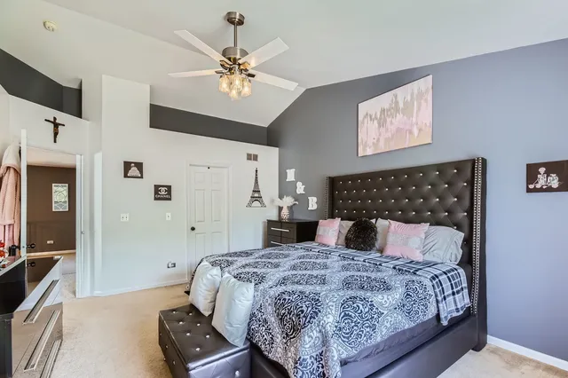 a bedroom with a large bed and a chandelier
