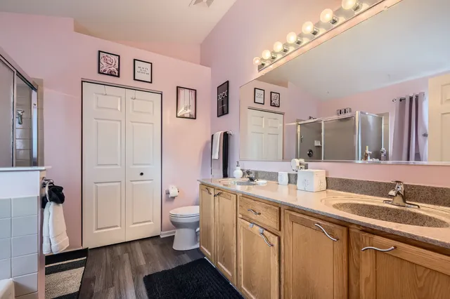 a spacious bathroom with a double vanity sink a mirror and a toilet