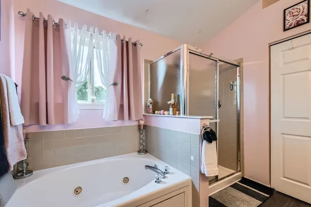 a bathroom with a tub a sink and a large mirror
