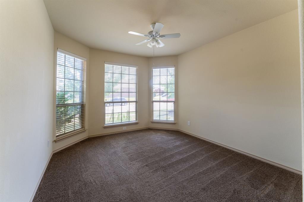 11156 Hawks Landing Road Fort Worth, TX 76052 - Photo 14 of 30 Room featuring angled walls, three large windows with horizontal blinds, neutral-toned carpeting, and a ceiling fan with integrated lighting