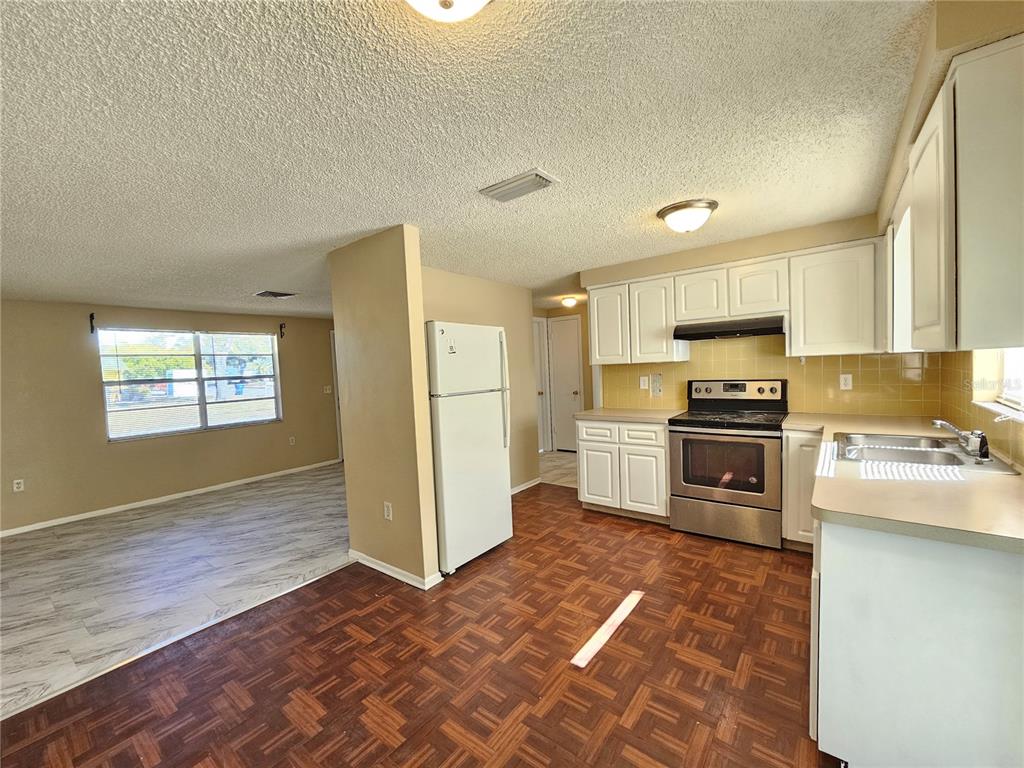 6324 Lomand Avenue New Port Richey, FL 34653 - Photo 5 of 16 a kitchen with granite countertop a refrigerator and a stove top oven