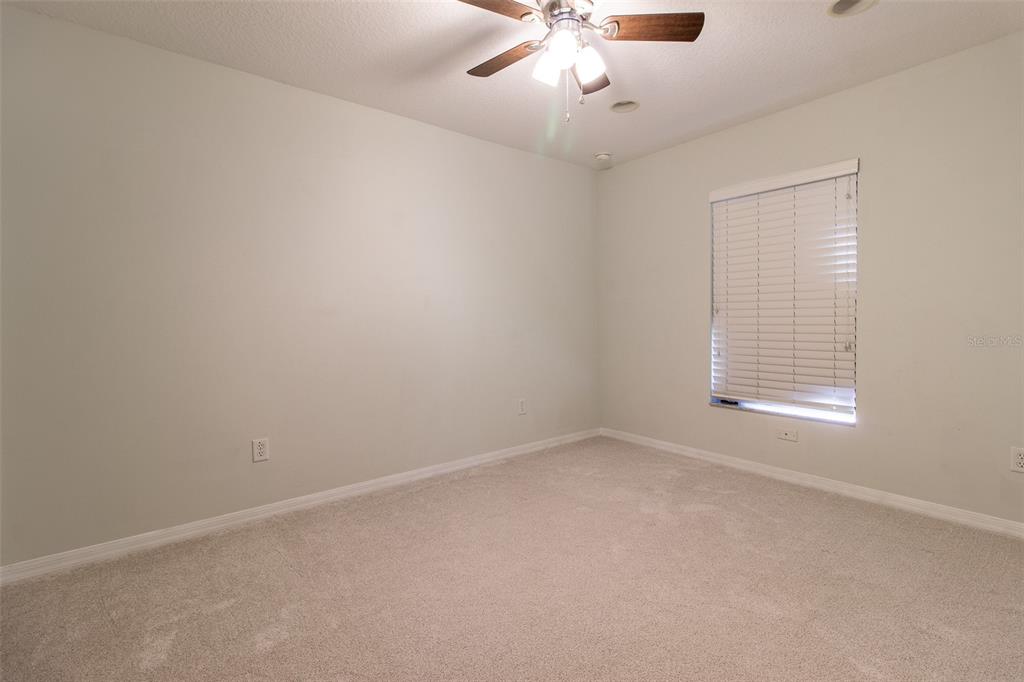 15691 Southwest 11th Court Road Ocala, FL 34473 - Photo 27 of 37 en empty room with windows and chandelier fan