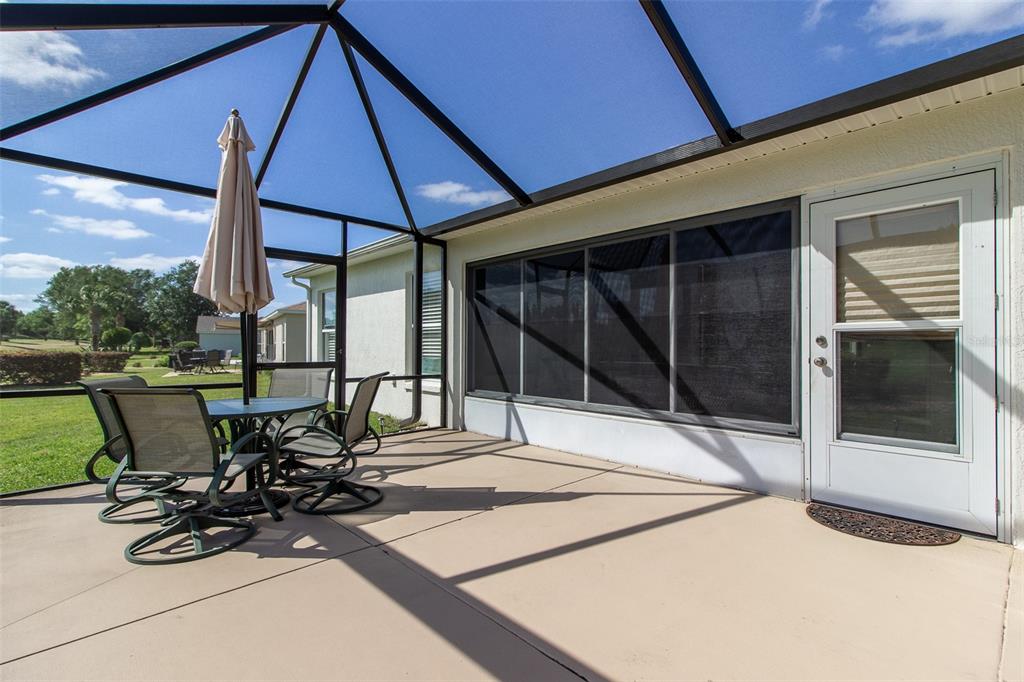 15691 Southwest 11th Court Road Ocala, FL 34473 - Photo 32 of 37 a view of a patio with table and chairs under an umbrella