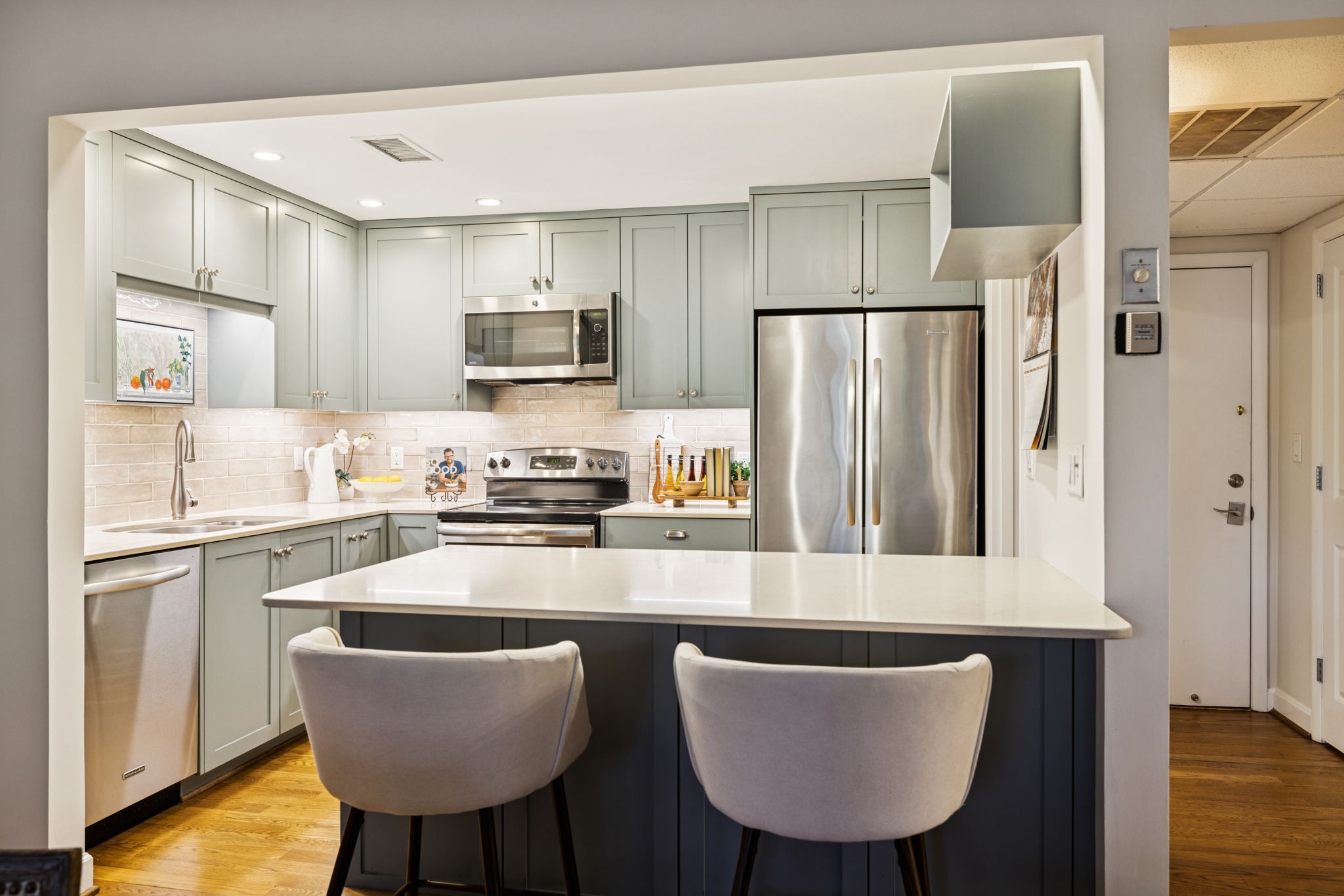 4215 Harding Pike, Unit 204 Nashville, TN 37205 - Photo 16 of 40 a kitchen with granite countertop a refrigerator a stove a sink dishwasher and white cabinets with wooden floor