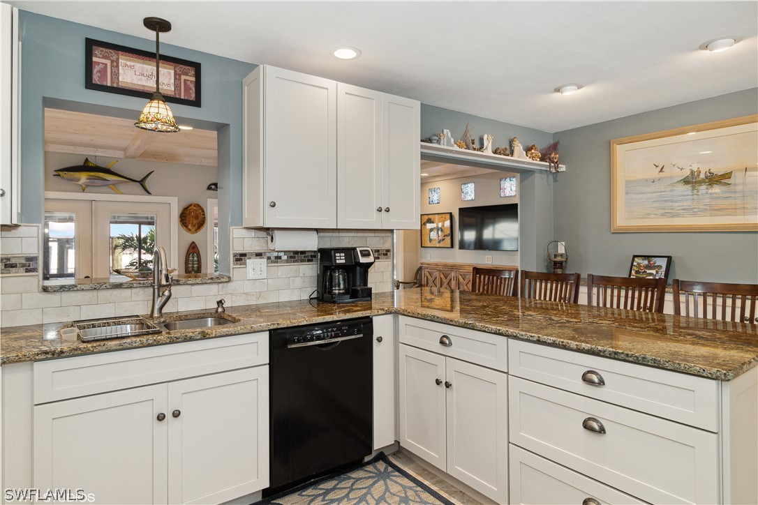 3554 Ruby Avenue St. James City, FL 33956 - Photo 19 of 43 a kitchen with granite countertop white cabinets and stainless steel appliances