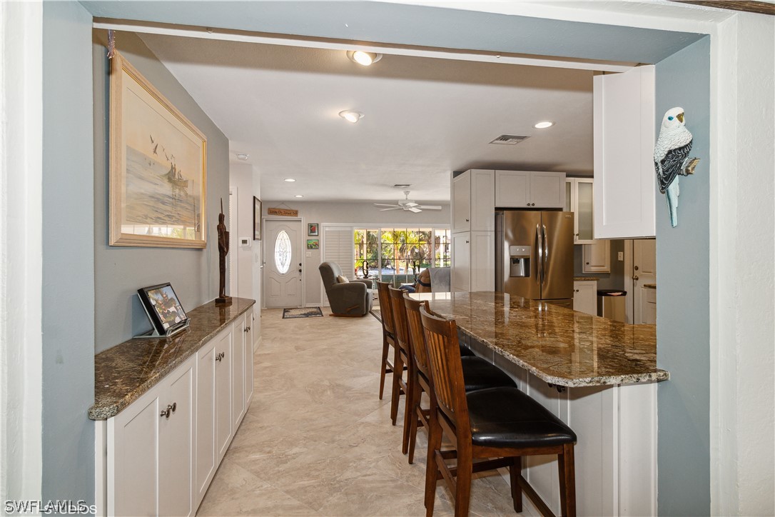 3554 Ruby Avenue St. James City, FL 33956 - Photo 22 of 43 a kitchen with a table chairs sink and cabinets