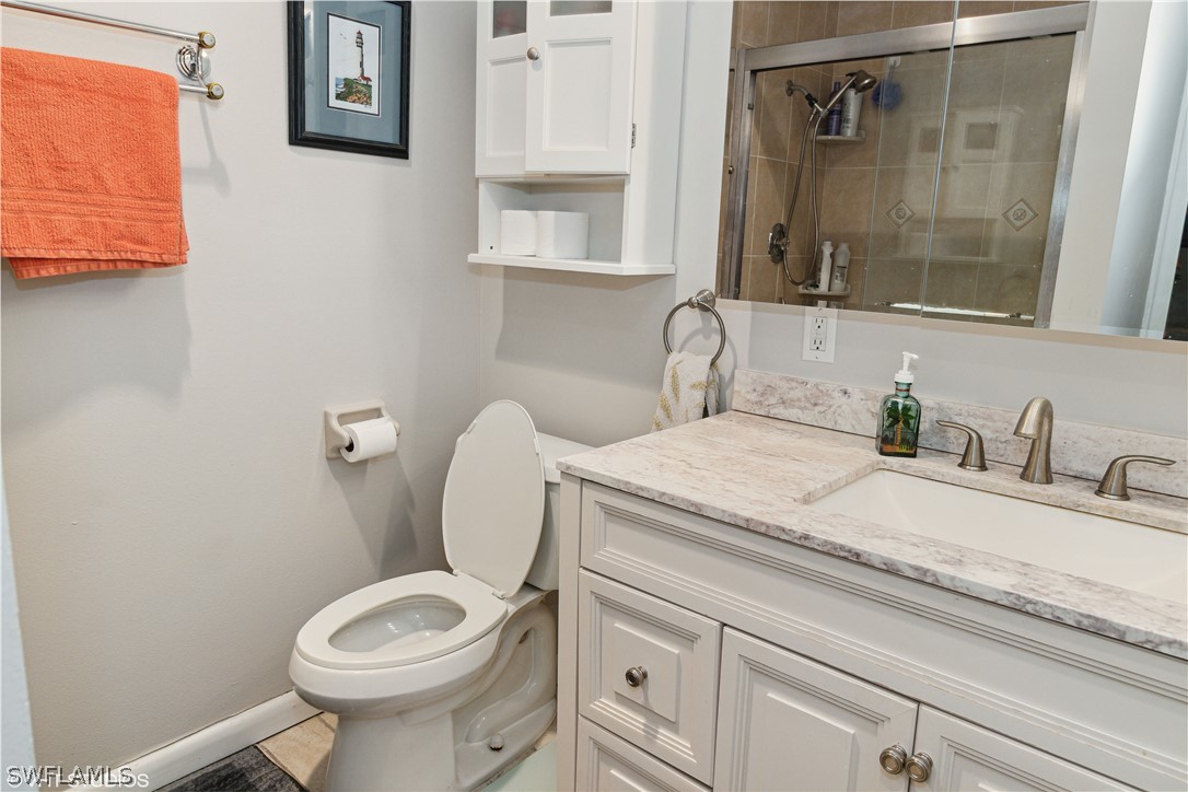 3554 Ruby Avenue St. James City, FL 33956 - Photo 31 of 43 a bathroom with a granite countertop toilet sink and mirror
