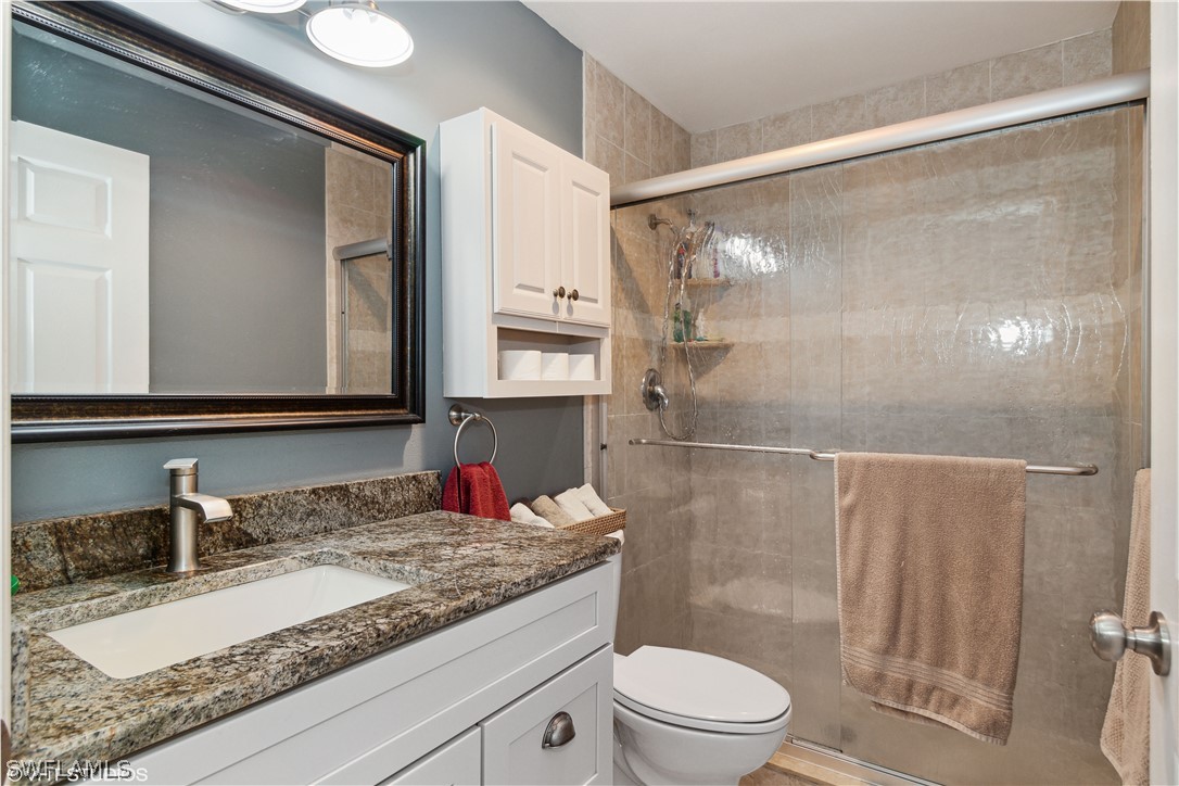 3554 Ruby Avenue St. James City, FL 33956 - Photo 35 of 43 a bathroom with a granite countertop sink toilet and shower