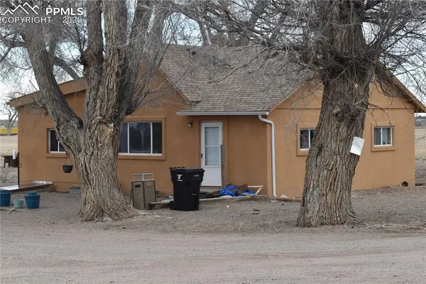 a front view of a house with a tree