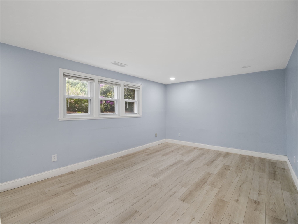 24 Bettys Pond Road, Unit K Barnstable, MA 02601 - Photo 12 of 40 a view of an empty room with wooden floor and a window