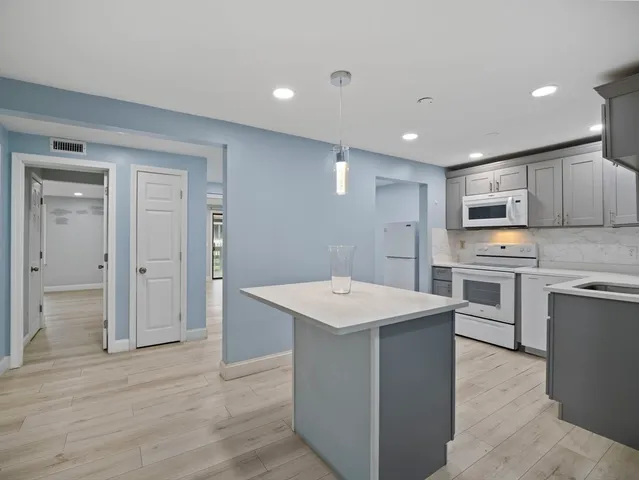 a kitchen with white cabinets and stainless steel appliances
