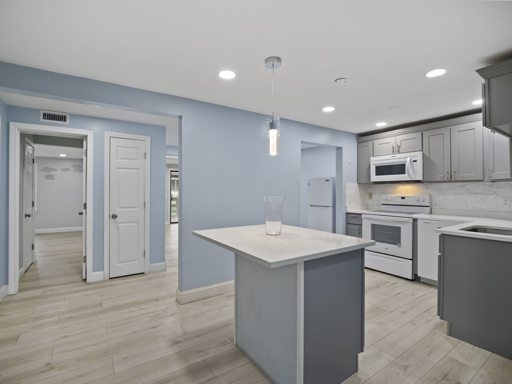 24 Bettys Pond Road, Unit K Barnstable, MA 02601 - Photo 16 of 40 a kitchen with white cabinets and stainless steel appliances