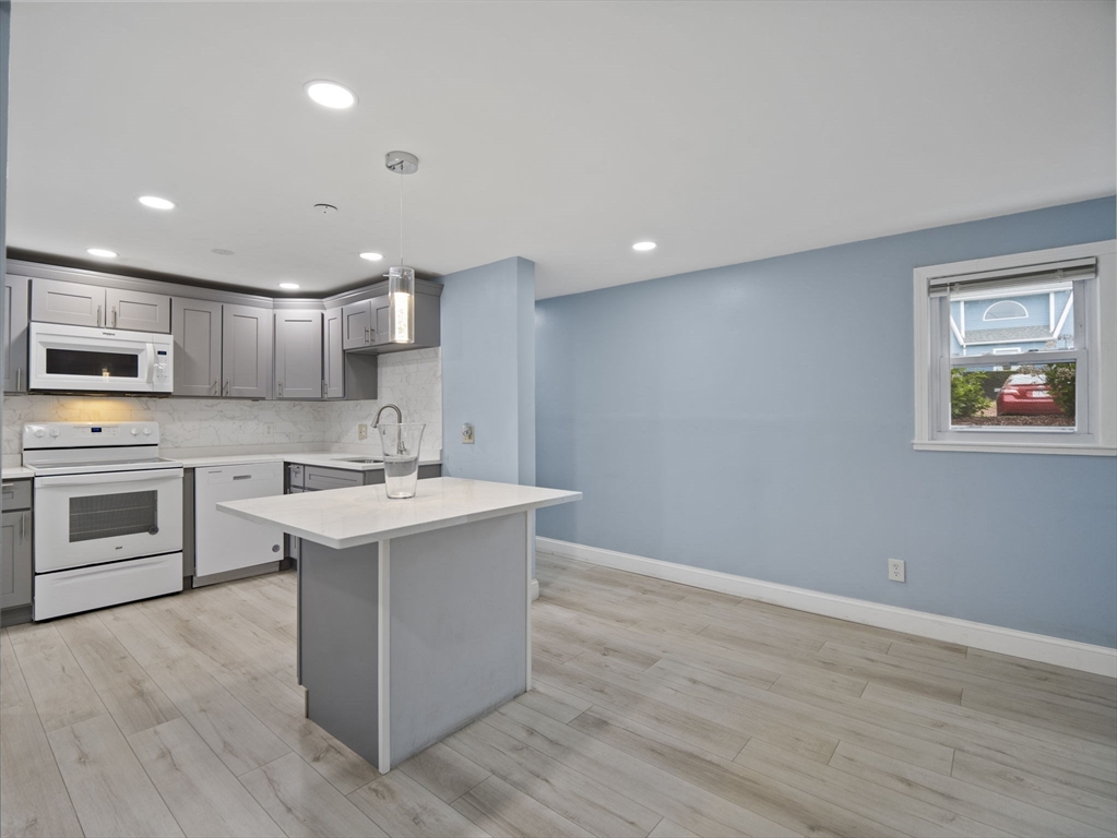 24 Bettys Pond Road, Unit K Barnstable, MA 02601 - Photo 17 of 40 a kitchen with a sink cabinets and wooden floor