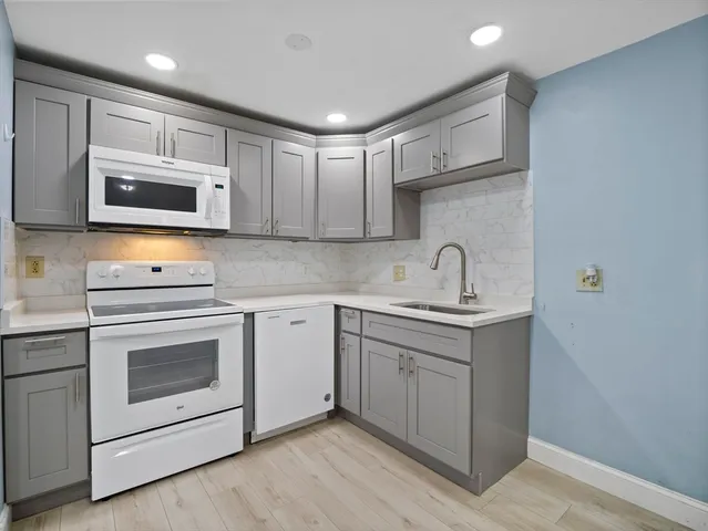 a kitchen with stainless steel appliances granite countertop a sink stove and microwave
