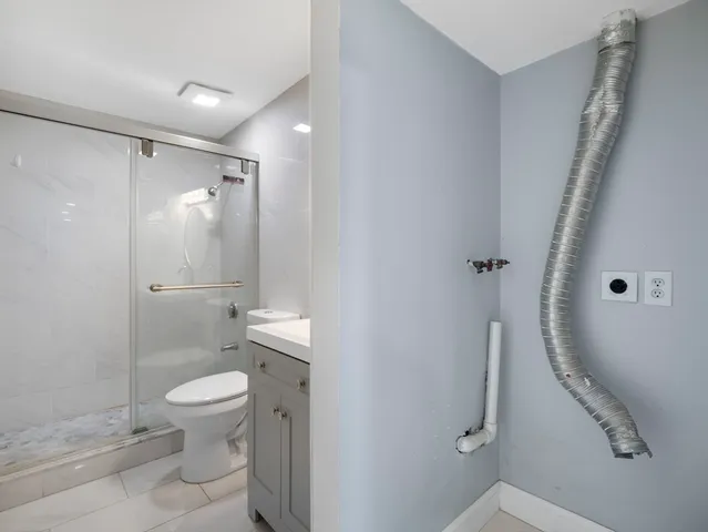 a bathroom with a sink a toilet and shower