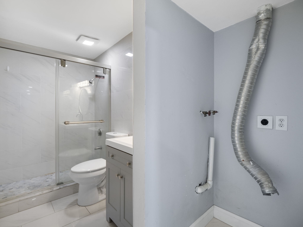 24 Bettys Pond Road, Unit K Barnstable, MA 02601 - Photo 32 of 40 a bathroom with a granite countertop sink toilet and shower