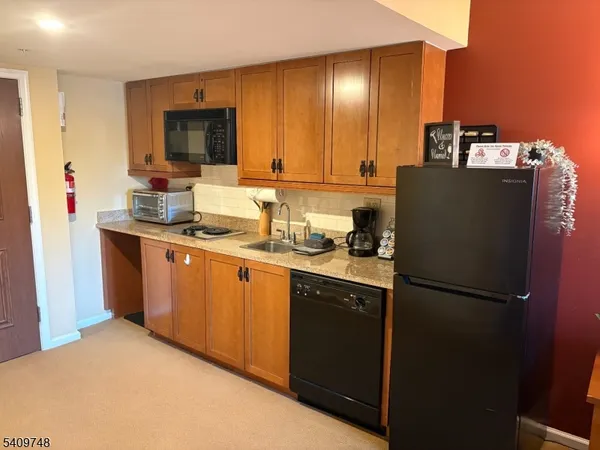 a kitchen with stainless steel appliances granite countertop a refrigerator a stove a sink and a microwave