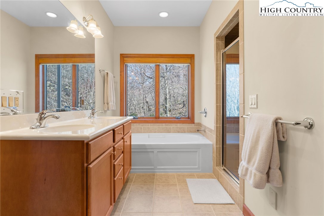 143 Wildflower Ridge, Unit 17D Sugar Mountain, NC 28604 - Photo 19 of 36 a bathroom with a tub sink and mirror