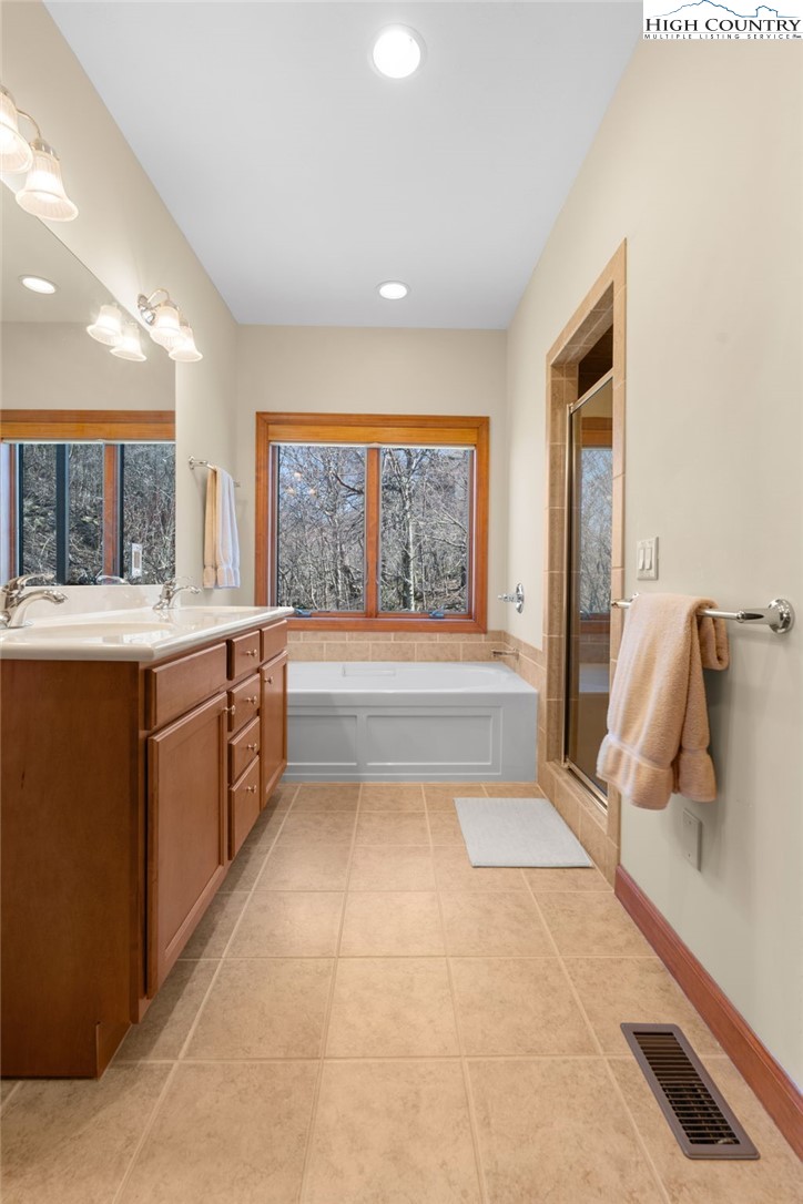 143 Wildflower Ridge, Unit 17D Sugar Mountain, NC 28604 - Photo 20 of 36 a spacious bathroom with a large mirror vanity and bathtub