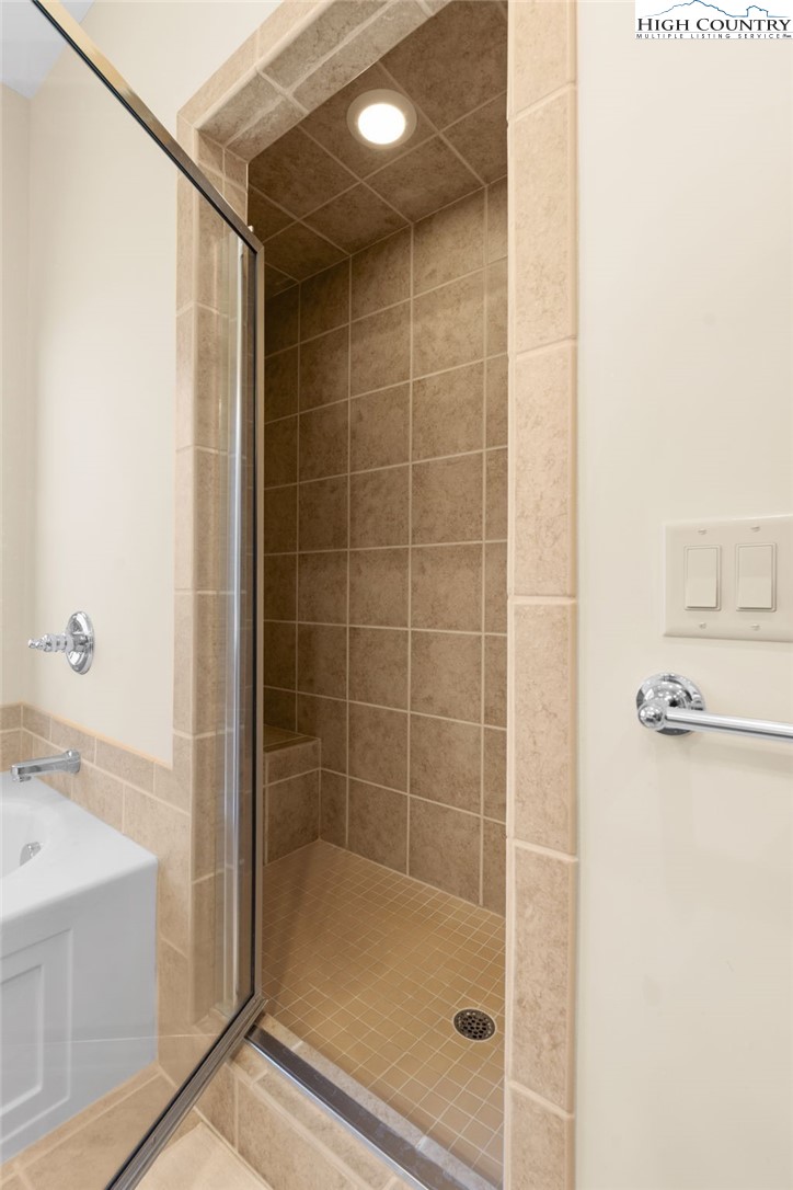 143 Wildflower Ridge, Unit 17D Sugar Mountain, NC 28604 - Photo 21 of 36 a bathroom with a bathtub and a shower