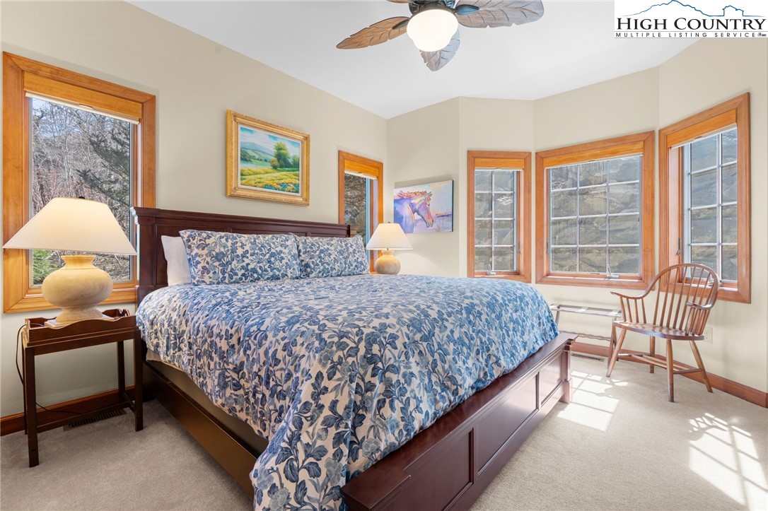 143 Wildflower Ridge, Unit 17D Sugar Mountain, NC 28604 - Photo 23 of 36 a bedroom with a large bed and a chandelier