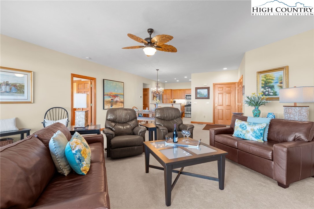 143 Wildflower Ridge, Unit 17D Sugar Mountain, NC 28604 - Photo 6 of 36 a living room with furniture a ceiling fan and a rug