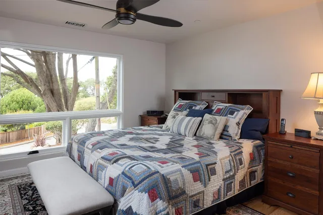 a bed sitting in a bedroom next to a large window