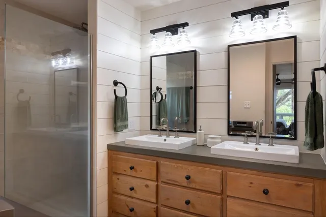 a bathroom with double vanity sinks and a mirror