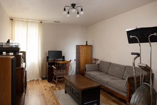 a living room with furniture a flat screen tv and a window
