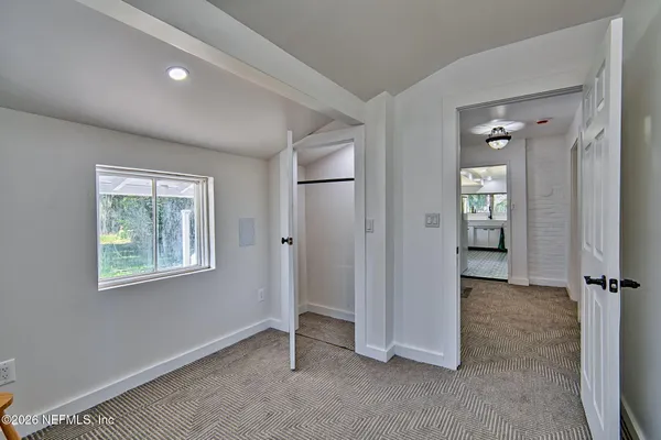 an empty room with windows and closet