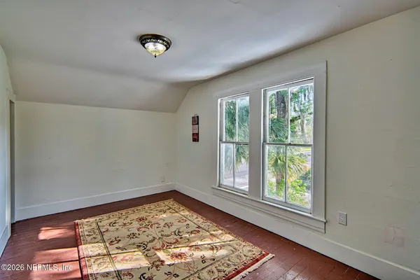 a view of a room with wooden floor and window
