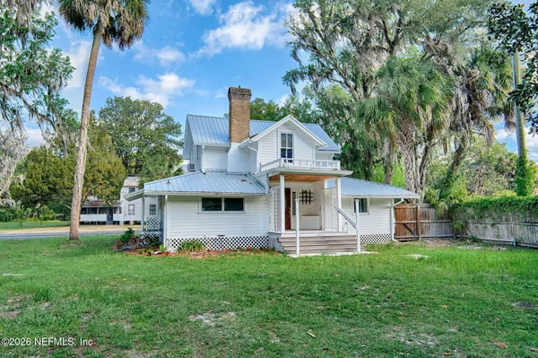 a front view of a house with a yard and trees