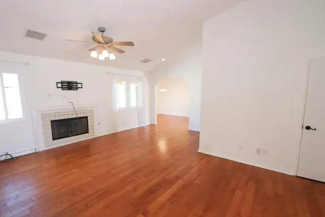 a view of an empty room with a fireplace and a window