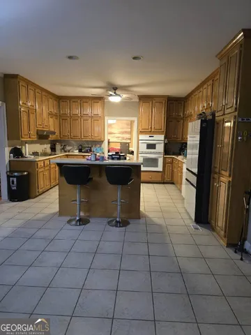a kitchen with a sink a counter top space appliances and cabinets