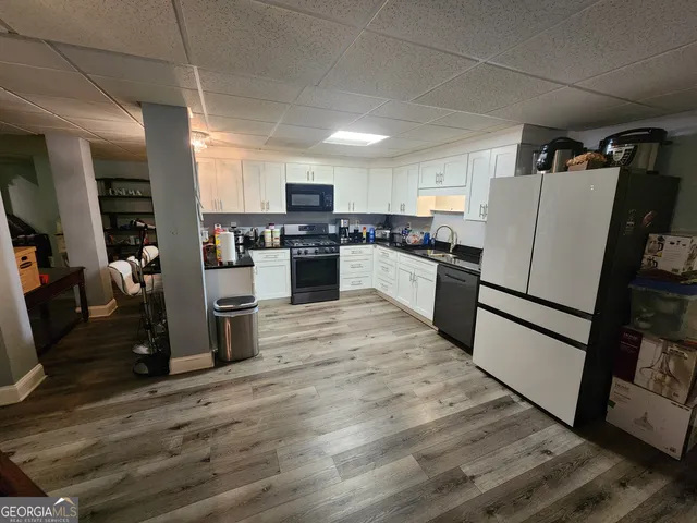 a kitchen with a refrigerator a stove top oven and sink