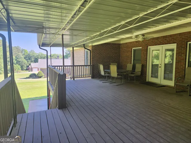 a view of a patio with table and chairs under an umbrella with wooden floor