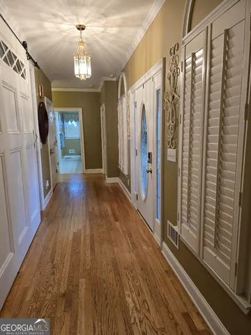 a view of a hallway with wooden floor and staircase